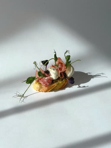 Beef basturma canapé on toasted baguette.