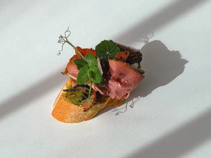 Pastrami and truffle canapé with microgreens.